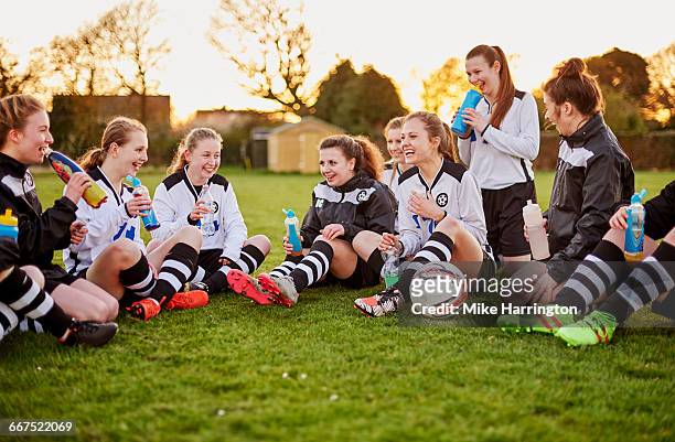 female football team relaxing after training - sport drinking bottle stock-fotos und bilder