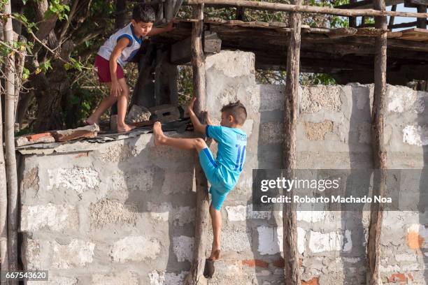 Cuban children playing baseball with rag ball. Trespassing a house backyard to look for the lost rag ball. The sport is a passion in the Caribbean...