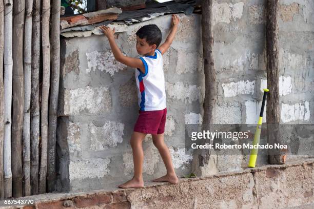 Cuban children playing baseball with rag ball. Trespassing a house backyard to look for the lost rag ball. The sport is a passion in the Caribbean...