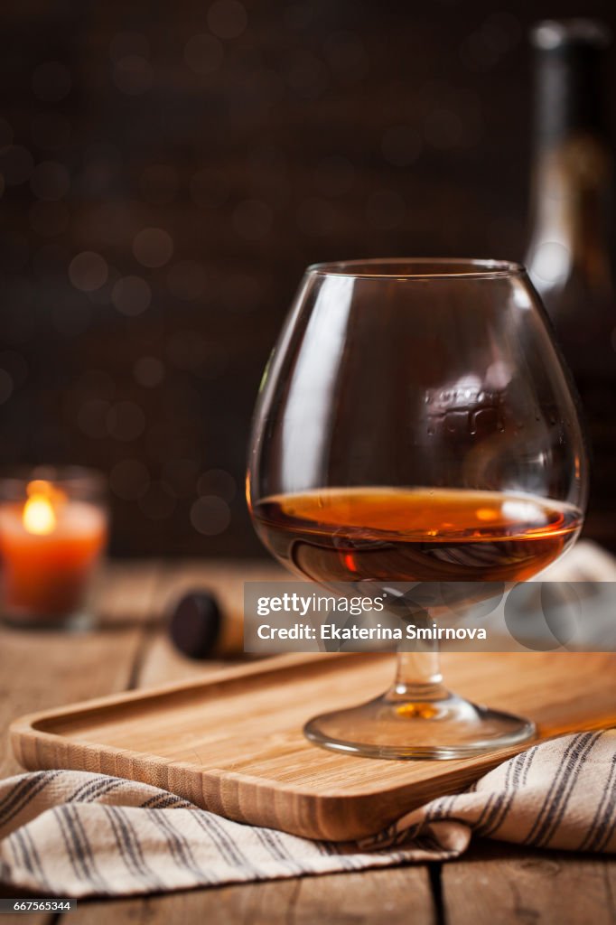 Glass of cognac on dark background