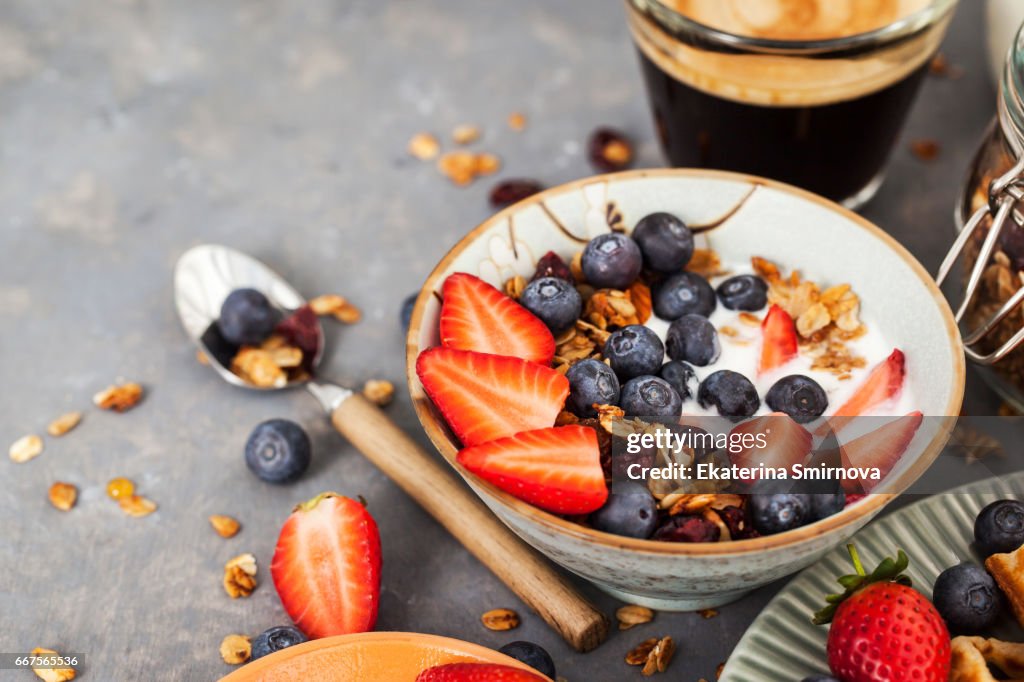 Breakfast table with cereal granola, fresh berries and coffee