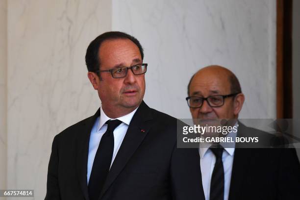 French President Francois Hollande , followed by French Defence Minister Jean-Yves Le Drian , leaves after a cabinet meeting at the Elysee Palace, in...