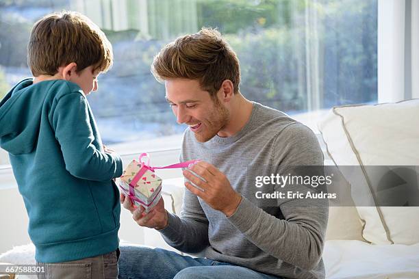 happy father and son with birthday gift - child giving gift stock-fotos und bilder