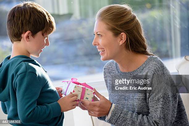 happy mother and son with birthday gift - child giving gift stock-fotos und bilder