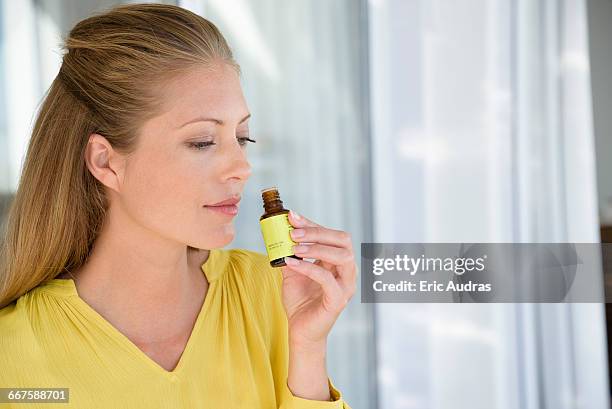 close-up of a woman smelling tea tree oil - aromaterapia imagens e fotografias de stock
