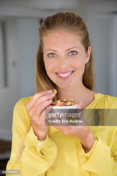 portrait of a happy beautiful woman eating nuts - eating nuts stock-fotos und bilder
