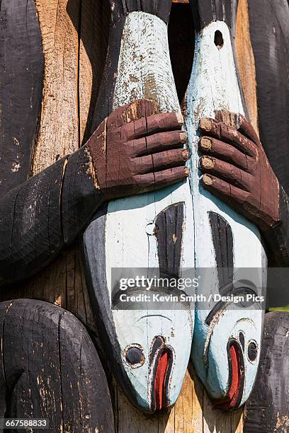 detail of a figure holding salmon carved into a totem pole, totem bight state historical park, ketchikan, southeast alaska, usa, spring - ketchikan stock pictures, royalty-free photos & images