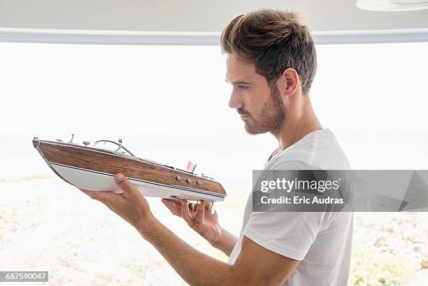 young man holding a model boat - toy boat stock pictures, royalty-free photos & images