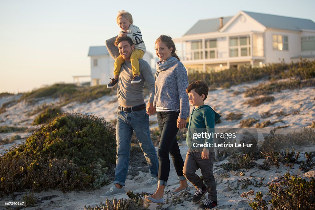 Couple with their two children walking on the beach