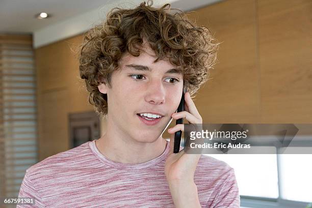 teenage boy talking on a mobile phone - one teenage boy only fotografías e imágenes de stock