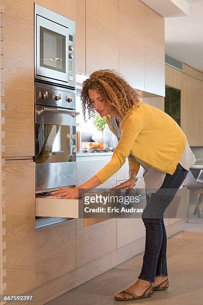 side profile of a woman opening drawer - bent stock pictures, royalty-free photos & images