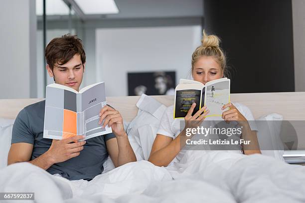 couple reading books on the bed - love magazine stock-fotos und bilder