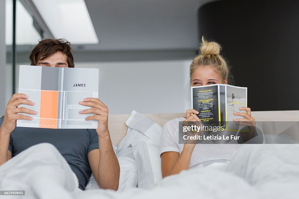 Young couple reading books on the bed