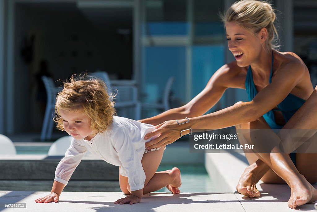 Young woman playing with her daughter at a resort