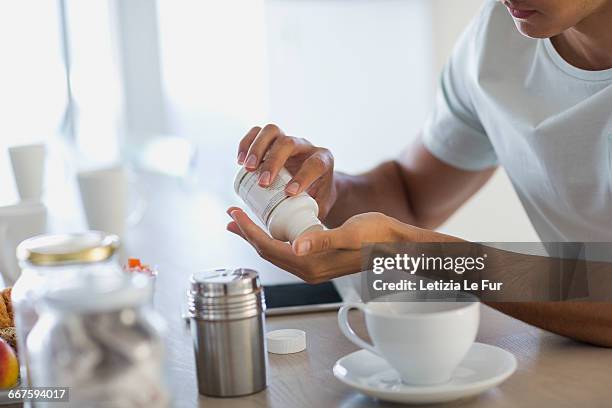 close-up of a young man taking nutritional supplement pills - nutritional supplement stockfoto's en -beelden