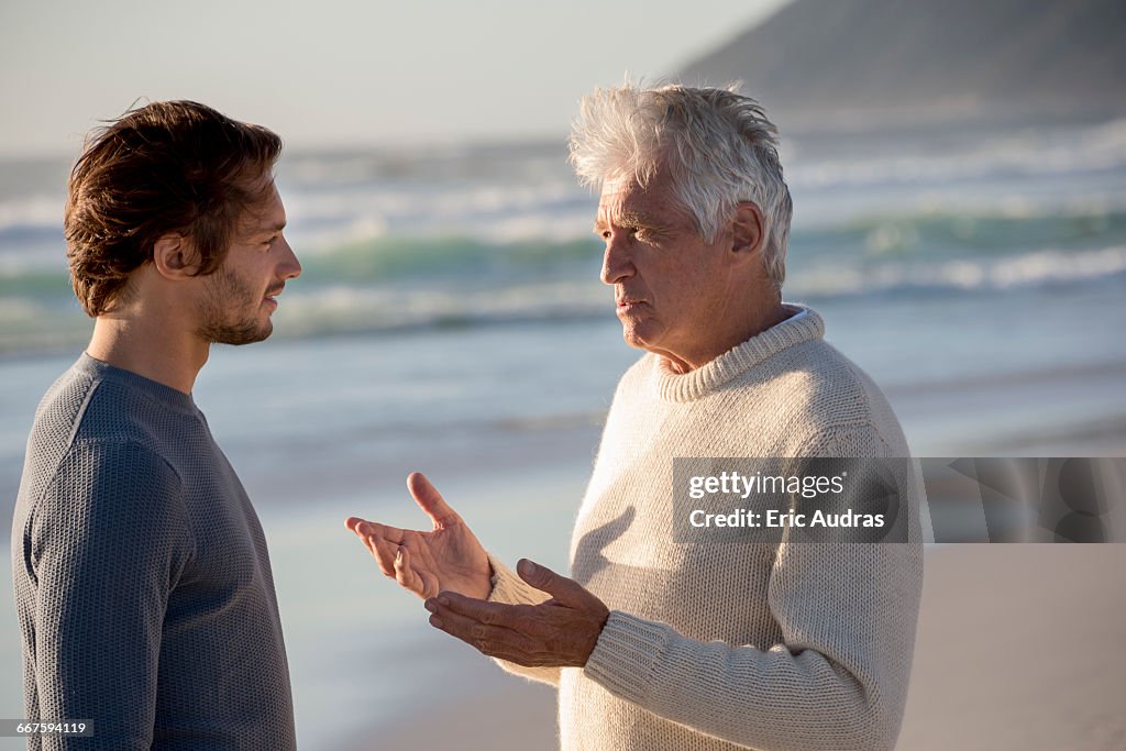 Happy father and son talking on the beach