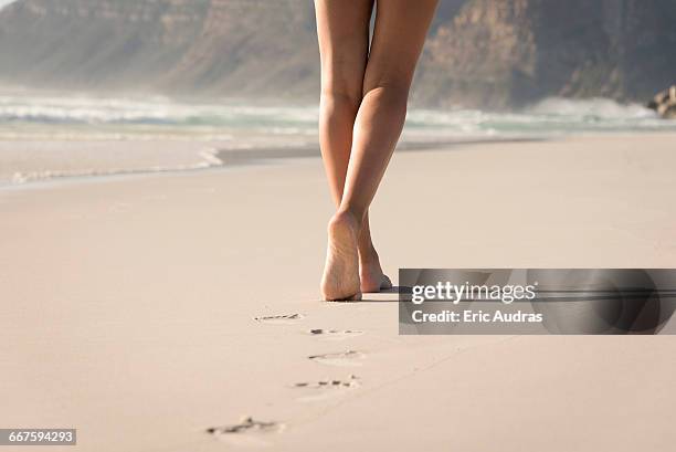 low section view of a woman walking on the beach - barefoot foto e immagini stock