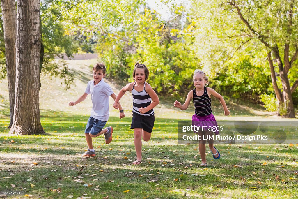 Three Siblings Racing In A Park High-Res Stock Photo - Getty Images