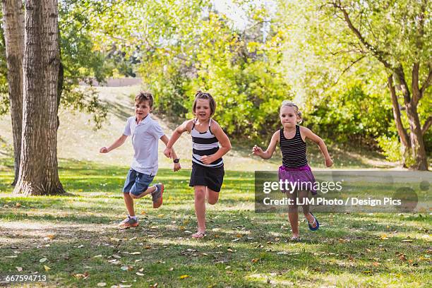 Three Kids Racing Three Siblings Racing In A Park High-Res Stock Photo - Getty Images