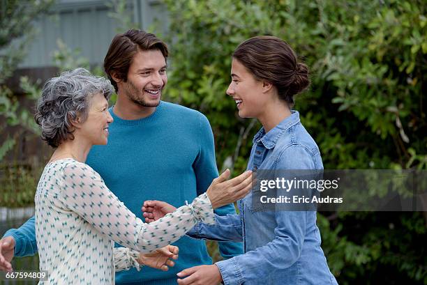 happy mature woman meet with young couple outside - introducing girlfriend stock pictures, royalty-free photos & images