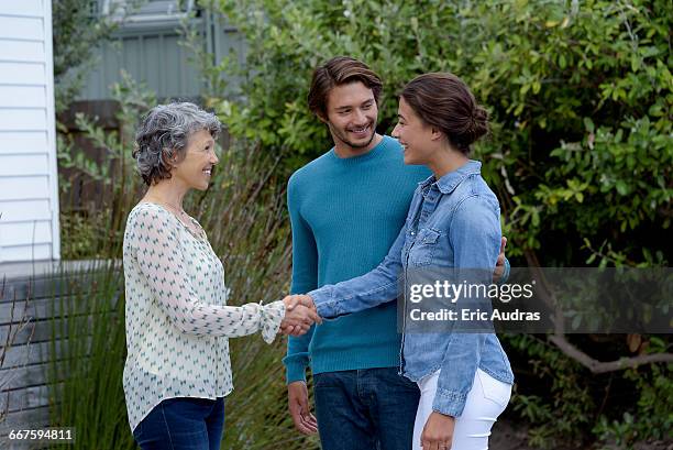 happy mature woman meet with young couple outside - introducing girlfriend stock pictures, royalty-free photos & images