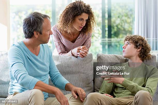 happy family talking in a living room at home - teen son stock pictures, royalty-free photos & images