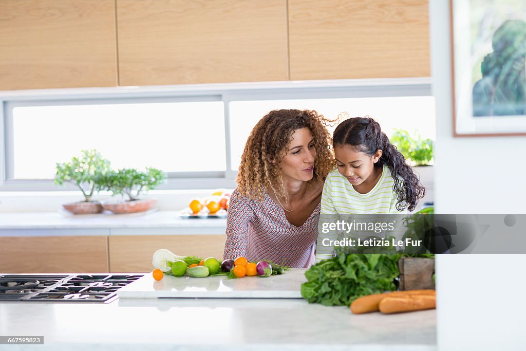 Young woman with daughter in kitchen