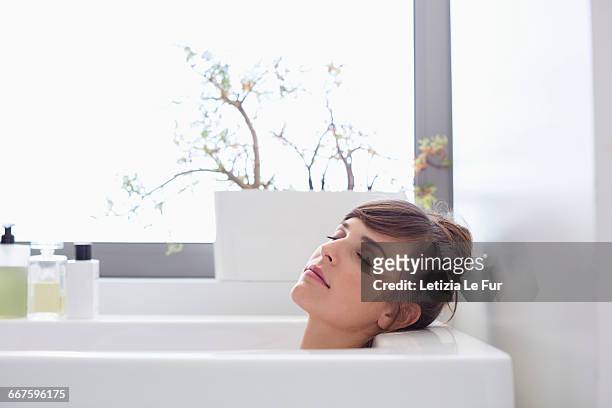 beautiful woman relaxing in bathtub - beautiful woman bath stockfoto's en -beelden