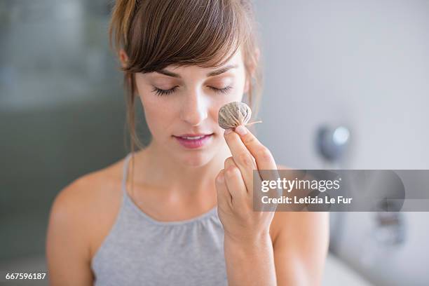 beautiful woman holding tea bags in front of her eye - tea bags stock pictures, royalty-free photos & images