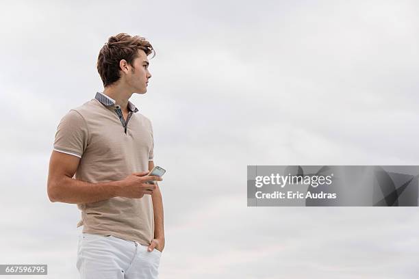 young man using a smart phone - men's water polo stockfoto's en -beelden