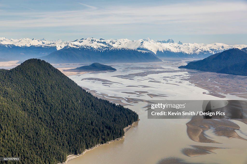 Aerial view of Woronkofski Island along the Stikine River Delta, low tide revealing mud flats below the snow capped peaks in the background
