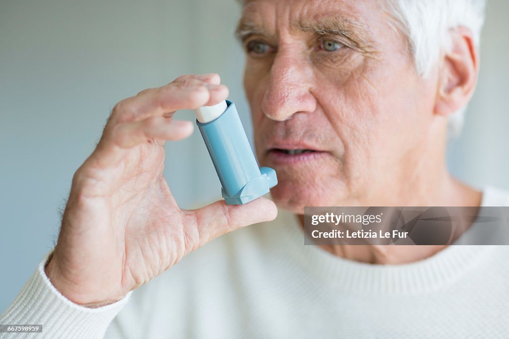 Close-up of a senior man using inhaler