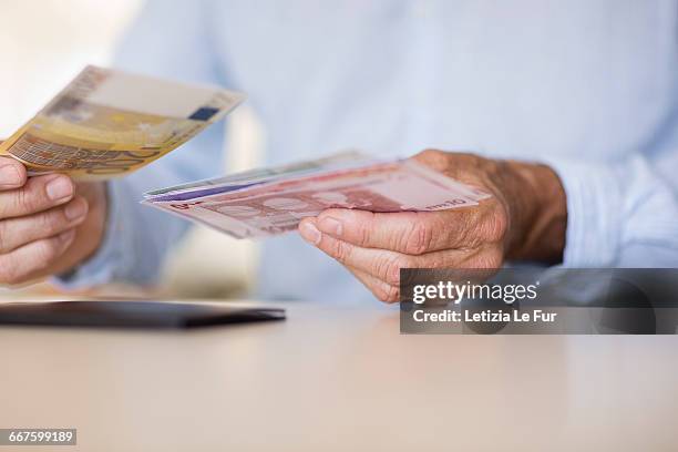 mid section view of a senior man holding currency notes - the euro 2016 stock pictures, royalty-free photos & images