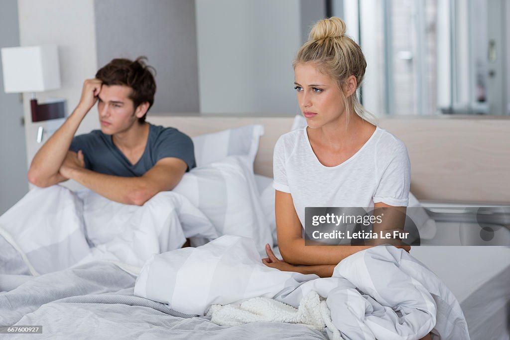 Young couple sitting on the bed with relationship difficulties