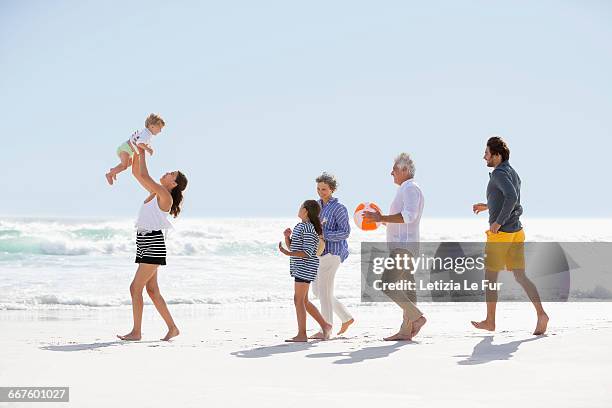 multi-generation family walking on the beach - young couple with baby stock pictures, royalty-free photos & images