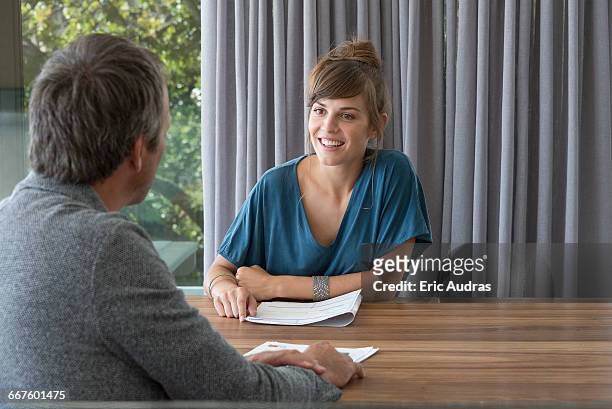 young woman in meeting with advisor in an office - business man sitting banking ストックフォトと画像