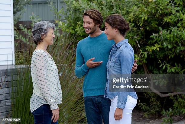 happy mature woman meet with young couple outside - introducing boyfriend stock pictures, royalty-free photos & images