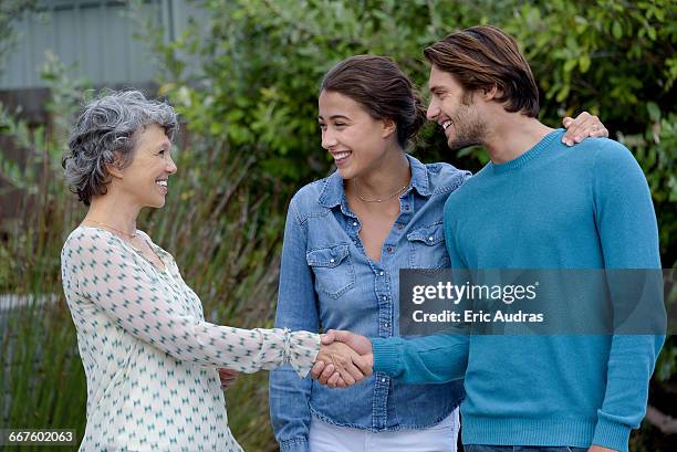 happy mature woman meet with young couple outside - introducing boyfriend stock pictures, royalty-free photos & images