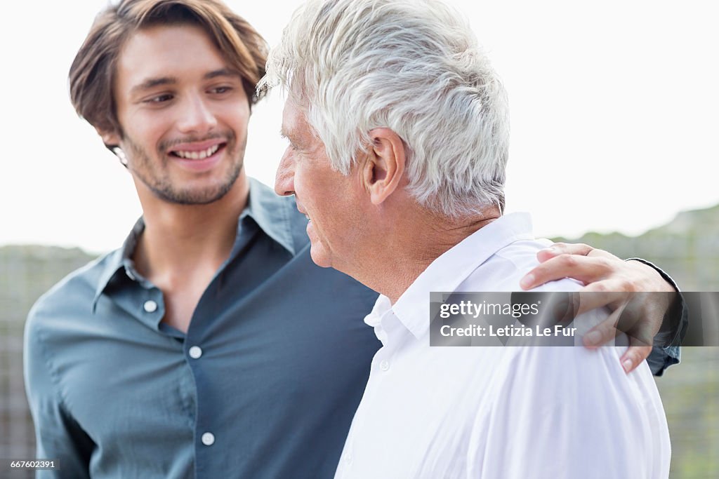 Happy father and son talking outside