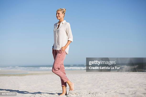 beautiful young woman walking on sunny beach - le sommer stock pictures, royalty-free photos & images