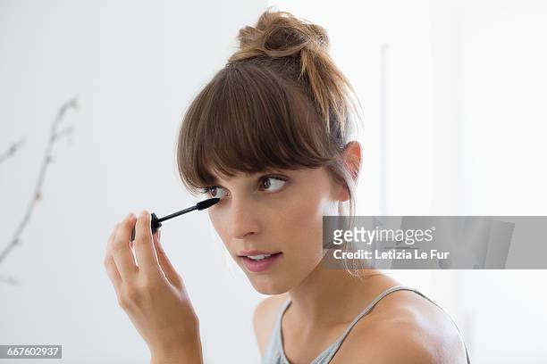 close-up of a woman applying mascara - close up woman eyes stock-fotos und bilder