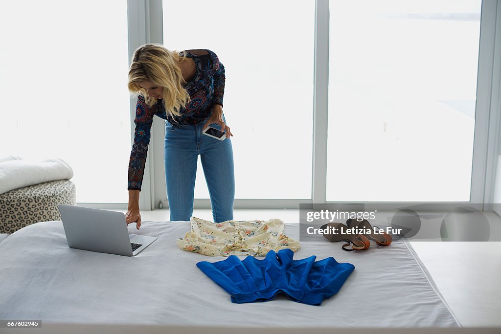 Young woman using a laptop in bedroom