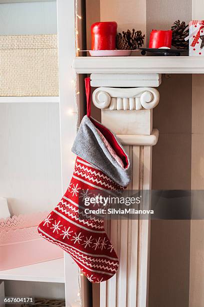 christmas stocking hanging on fireplace - stockings stockfoto's en -beelden