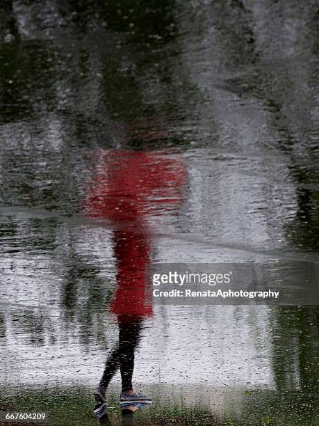 Reflection of a girl standing in street with umbrella