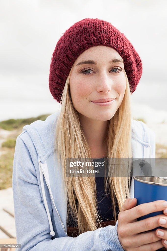 Young woman holding cup of coffee on cold day