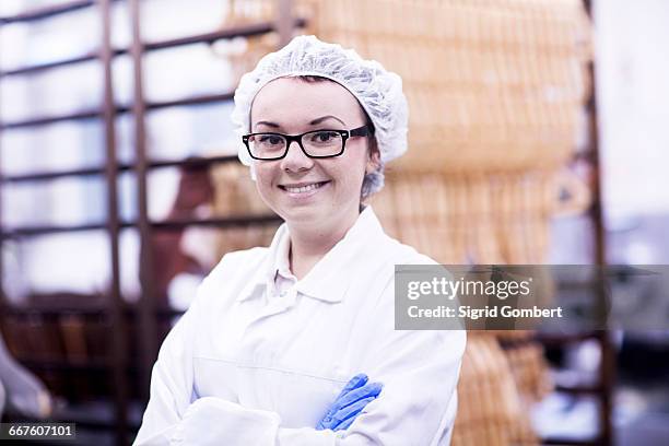 factory worker wearing overall and hair net looking at camera - hair net stock pictures, royalty-free photos & images