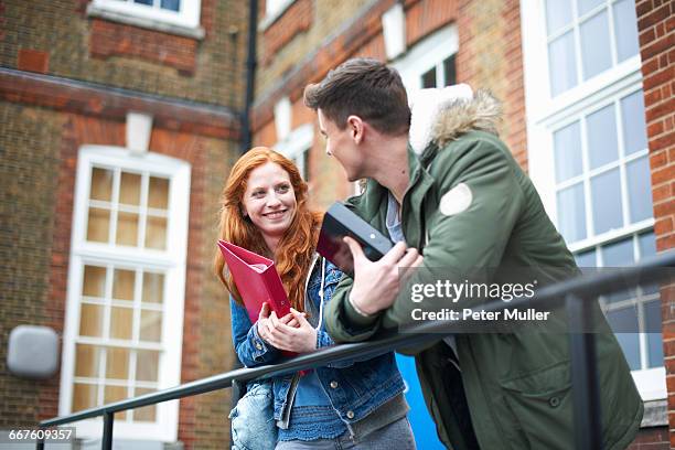 young college student couple leaning against campus handrail - result stock pictures, royalty-free photos & images