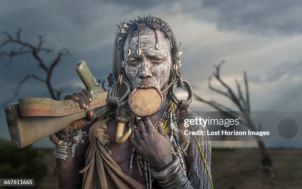 woman of the mursi tribe with kalashnikov gun, omo valley, ethiopia - mursi people stock pictures, royalty-free photos & images