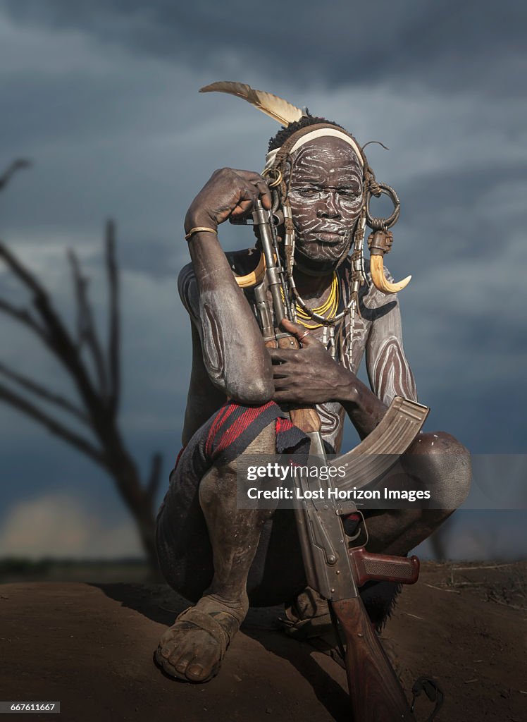 Young warrior of the Mursi tribe with Kalashnikov gun, Omo Valley, Ethiopia