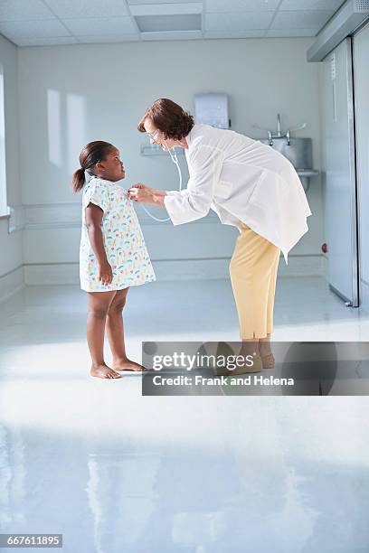 female doctor using stethoscope on girl in hospital childrens ward - doctor stethoscope patient whole body stock pictures, royalty-free photos & images